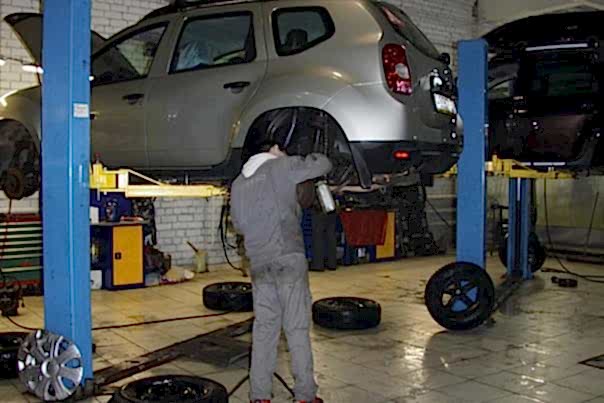 мастер сливает использованное масло из коробки